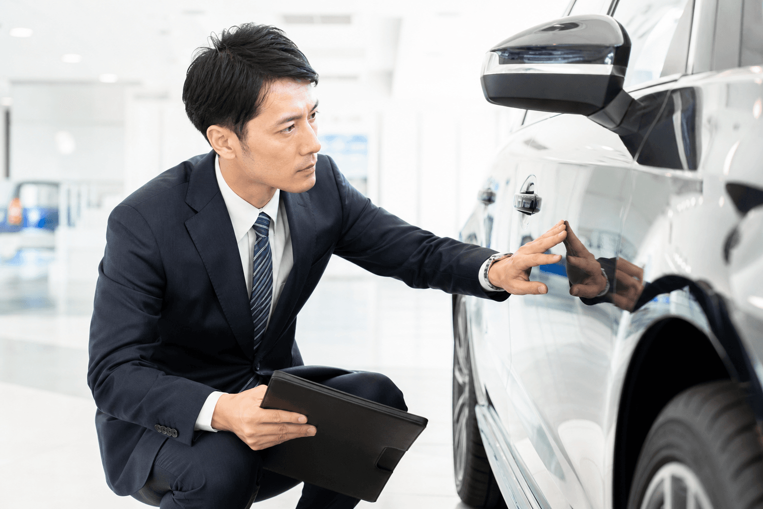 丁寧に車両を点検するサラリーマン